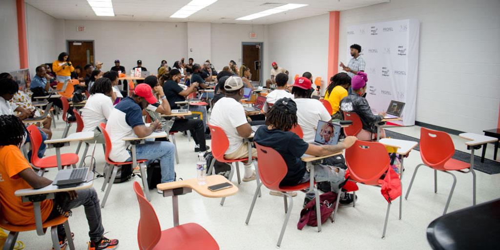 a man speaks to a classroom of young adults