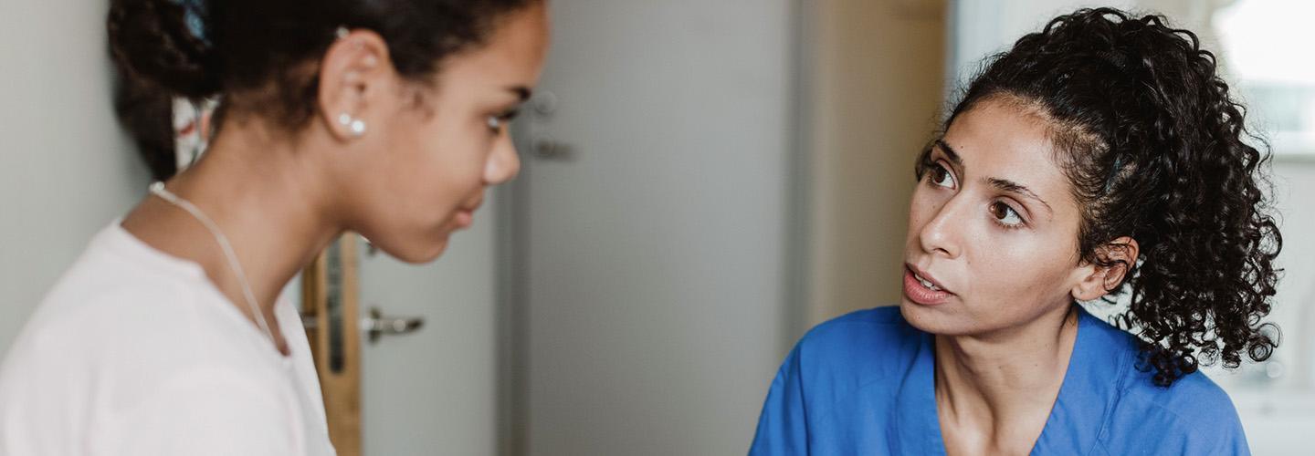 a young woman talks to her doctor