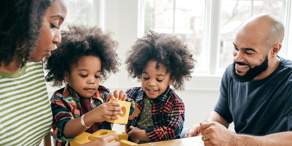 Two children play with their parents