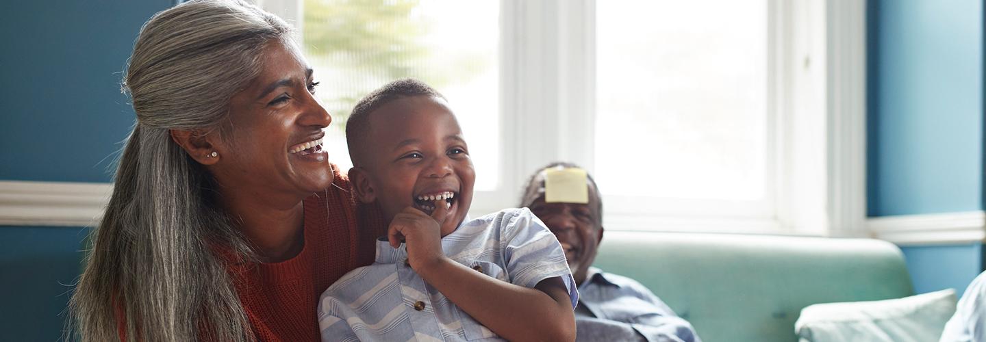 smiling grandmother holds grandchild