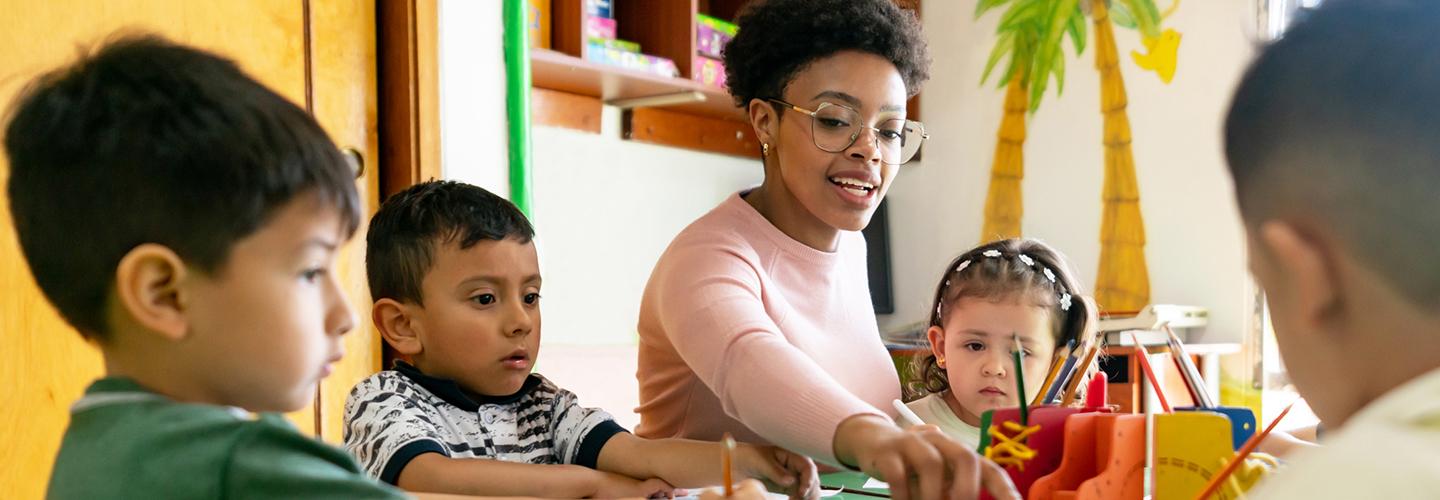 a teacher works with a group of young students