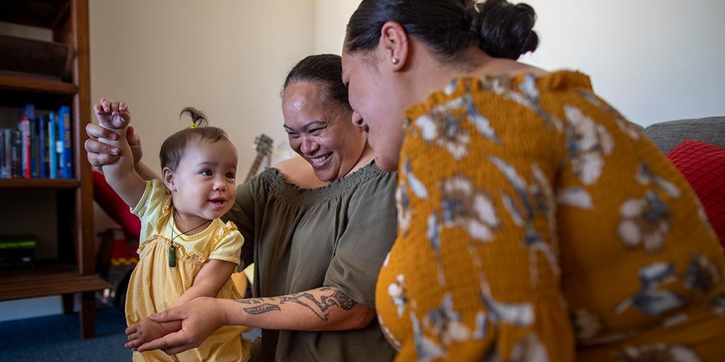 a child plays with her mom and grandmother